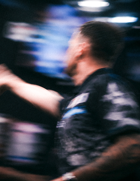 Darts player throwing a dart motion shot portrait